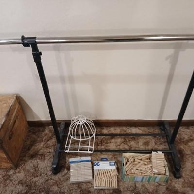 Portable clothes rack with packages of brand-new and opened clothes pins and a baseball cap cleaning tool
