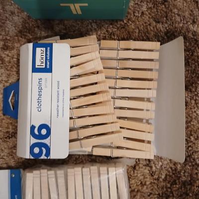 Portable clothes rack with packages of brand-new and opened clothes pins and a baseball cap cleaning tool