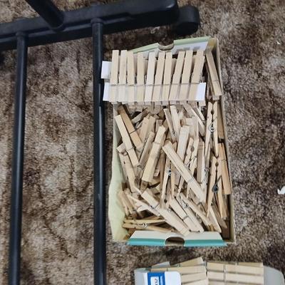 Portable clothes rack with packages of brand-new and opened clothes pins and a baseball cap cleaning tool