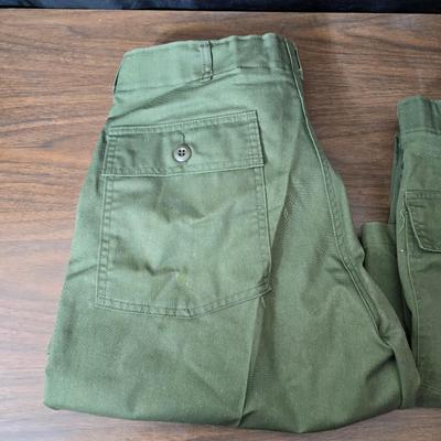 a grouping of U.S. military-issue OG-107 utility uniforms and a old old machete