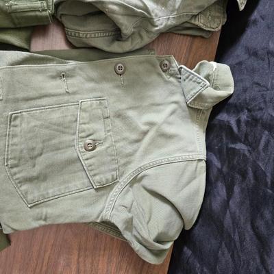 a grouping of U.S. military-issue OG-107 utility uniforms and a old old machete