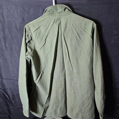 a grouping of U.S. military-issue OG-107 utility uniforms and a old old machete