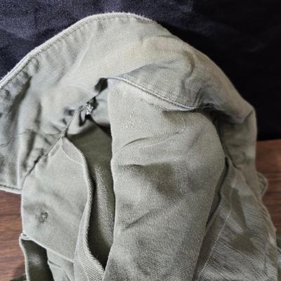 a grouping of U.S. military-issue OG-107 utility uniforms and a old old machete