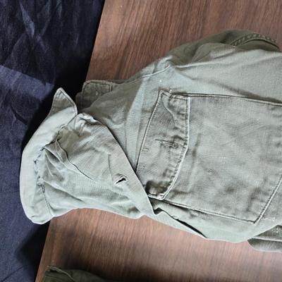 a grouping of U.S. military-issue OG-107 utility uniforms and a old old machete