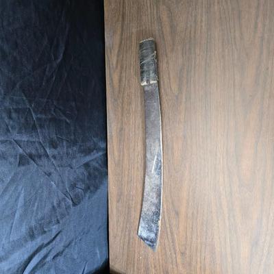 a grouping of U.S. military-issue OG-107 utility uniforms and a old old machete