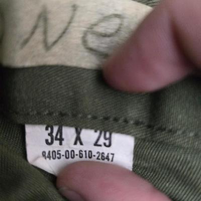 a grouping of U.S. military-issue OG-107 utility uniforms and a old old machete