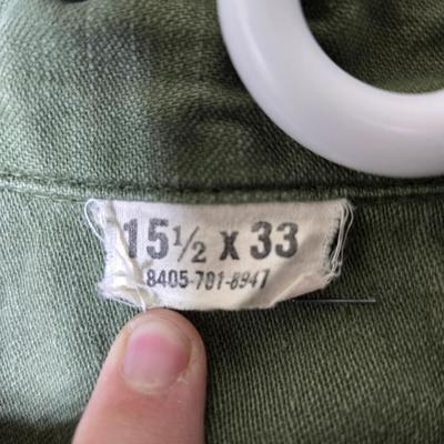 a grouping of U.S. military-issue OG-107 utility uniforms and a old old machete