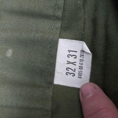 a grouping of U.S. military-issue OG-107 utility uniforms and a old old machete