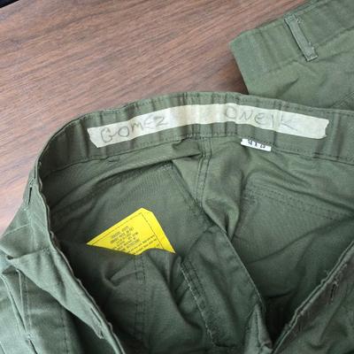 a grouping of U.S. military-issue OG-107 utility uniforms and a old old machete