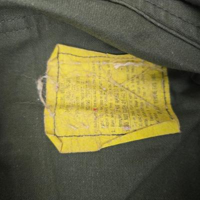 a grouping of U.S. military-issue OG-107 utility uniforms and a old old machete