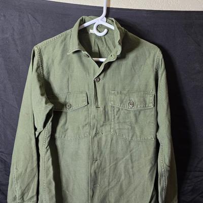 a grouping of U.S. military-issue OG-107 utility uniforms and a old old machete