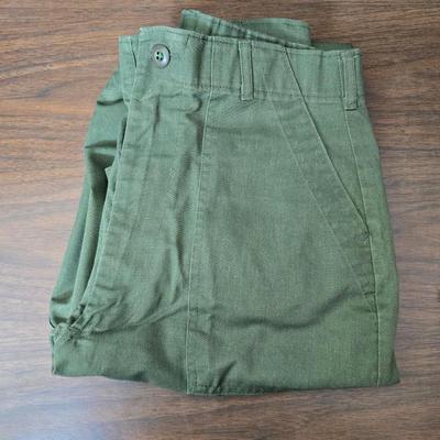 a grouping of U.S. military-issue OG-107 utility uniforms and a old old machete