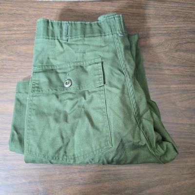 a grouping of U.S. military-issue OG-107 utility uniforms and a old old machete