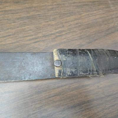 a grouping of U.S. military-issue OG-107 utility uniforms and a old old machete