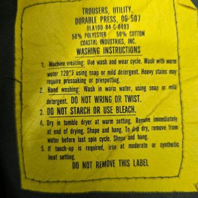 a grouping of U.S. military-issue OG-107 utility uniforms and a old old machete