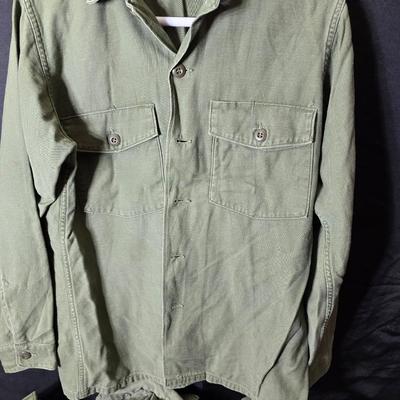 a grouping of U.S. military-issue OG-107 utility uniforms and a old old machete