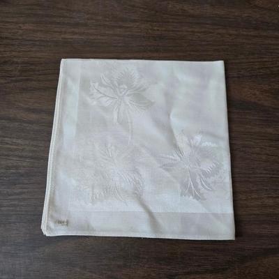 Two framed cross stitch wall art with a collection of pretty doilies