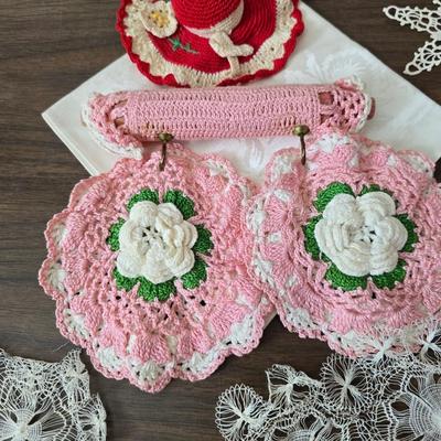 Two framed cross stitch wall art with a collection of pretty doilies
