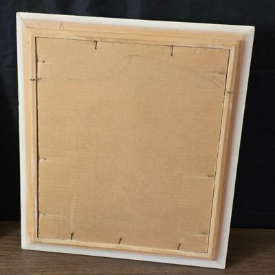 Two framed cross stitch wall art with a collection of pretty doilies