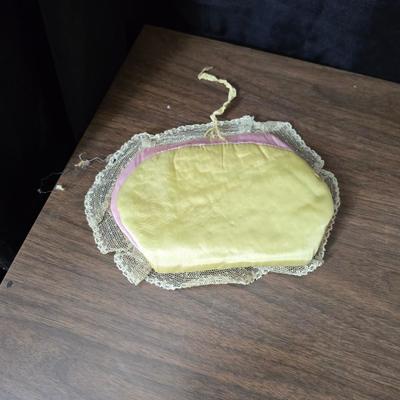 Two framed cross stitch wall art with a collection of pretty doilies