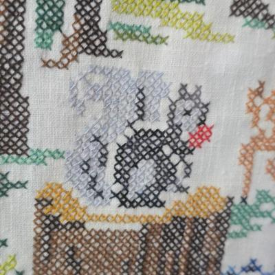 Two framed cross stitch wall art with a collection of pretty doilies