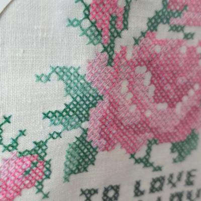 Two framed cross stitch wall art with a collection of pretty doilies