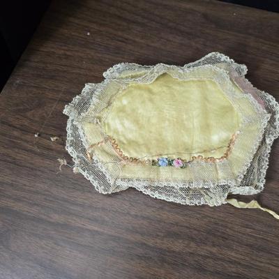 Two framed cross stitch wall art with a collection of pretty doilies