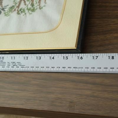 Two framed cross stitch wall art with a collection of pretty doilies