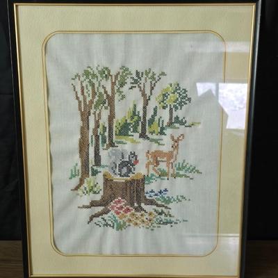 Two framed cross stitch wall art with a collection of pretty doilies