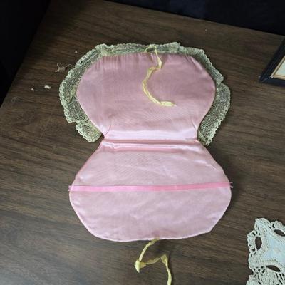 Two framed cross stitch wall art with a collection of pretty doilies