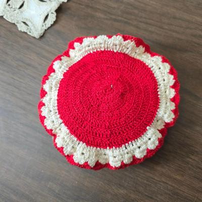 Two framed cross stitch wall art with a collection of pretty doilies