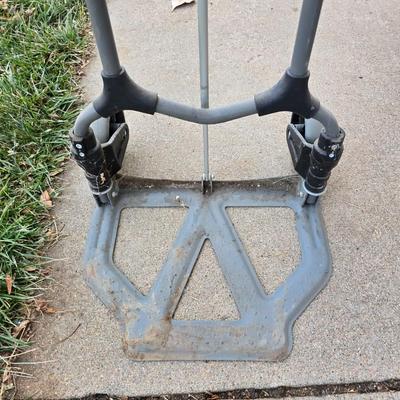 Two folding carts with assortment of luggage