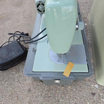 Vintage Sears Kenmore sewing machine with small tote of sewing supplies