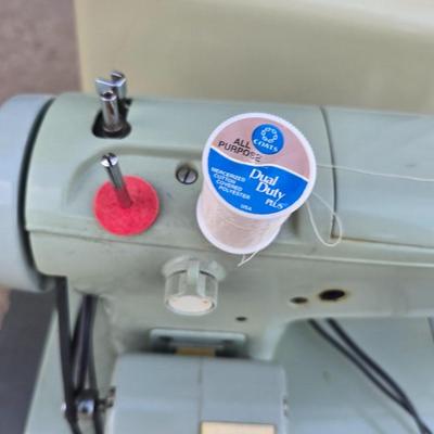 Vintage Sears Kenmore sewing machine with small tote of sewing supplies