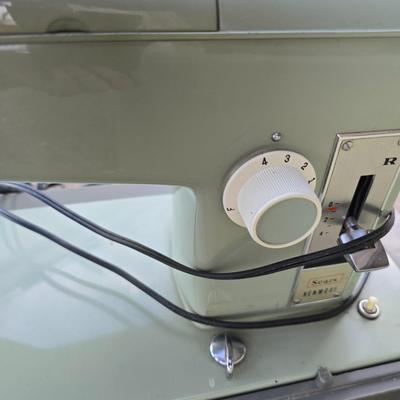 Vintage Sears Kenmore sewing machine with small tote of sewing supplies