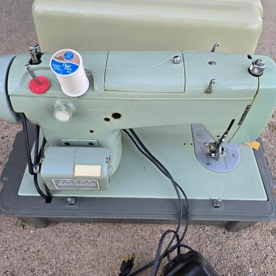 Vintage Sears Kenmore sewing machine with small tote of sewing supplies