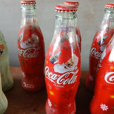 New CocaCola Starr bottle opener with a collection of glass Santa & Broncos coke bottles