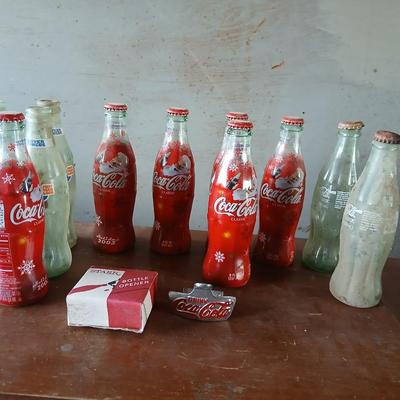 New CocaCola Starr bottle opener with a collection of glass Santa & Broncos coke bottles