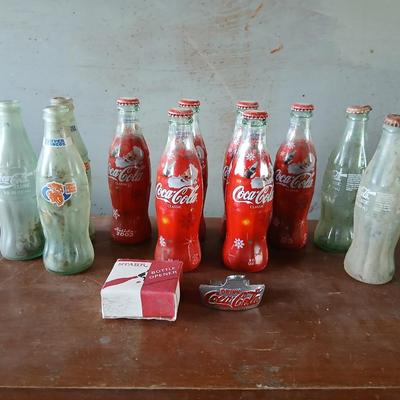 New CocaCola Starr bottle opener with a collection of glass Santa & Broncos coke bottles