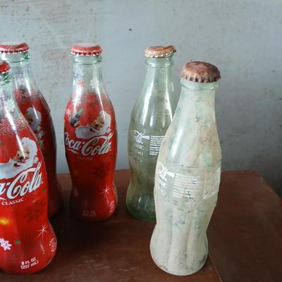 New CocaCola Starr bottle opener with a collection of glass Santa & Broncos coke bottles