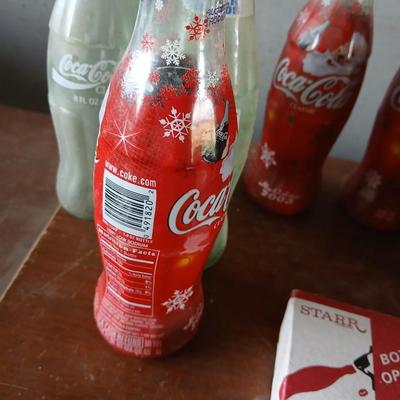 New CocaCola Starr bottle opener with a collection of glass Santa & Broncos coke bottles