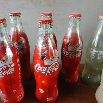 New CocaCola Starr bottle opener with a collection of glass Santa & Broncos coke bottles