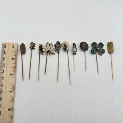 LOT 72: Collection of Stick Pins: Scrimshaw Style, Raggedy Ann, Four Leaf Clover & More