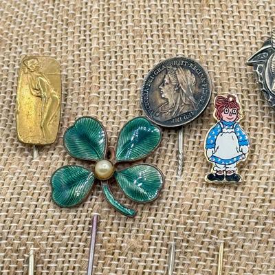 LOT 72: Collection of Stick Pins: Scrimshaw Style, Raggedy Ann, Four Leaf Clover & More