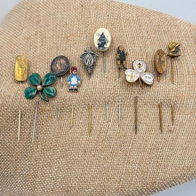 LOT 72: Collection of Stick Pins: Scrimshaw Style, Raggedy Ann, Four Leaf Clover & More