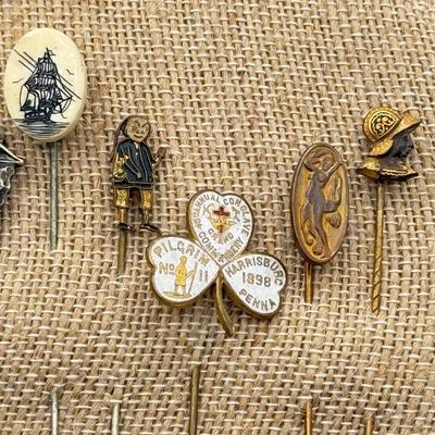 LOT 72: Collection of Stick Pins: Scrimshaw Style, Raggedy Ann, Four Leaf Clover & More