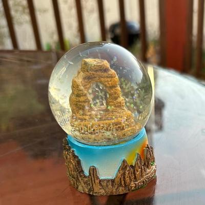 souvenir snow globe featuring Utah's iconic red rock arches