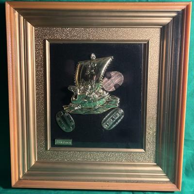 Sale Photo Thumbnail #5: Two framed artworks featuring gold relief designs. 24kt Gold Plated. One piece showcases a traditional Japanese-style ship with additional elements, including waves and coins, against a black velvet background framed in ornate gold-tone frames. The large 