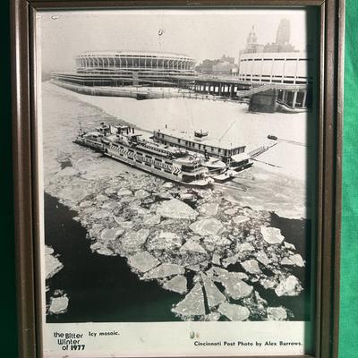 Sale Photo Thumbnail #29: A framed black-and-white photo titled 'The Bitter Winter of 1977,' featuring a steamboat surrounded by floating ice. The background includes a view of Riverfront Stadium in Cincinnati. The photo is attributed to Alex Burrows and published by the Cincinnat
