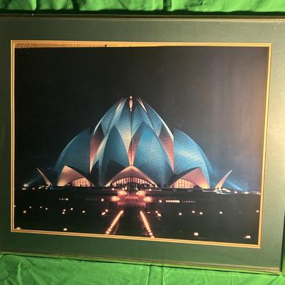 Sale Photo Thumbnail #40: Framed photograph featuring the nighttime view of the Lotus Temple, an architectural marvel. The photo is mounted with a black and gold border and housed in a green-toned frame. It highlights the illuminated petals of the temple against a dark backdrop. E
